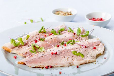 smoked trout fillet with pink pepper and fresh cressの写真素材