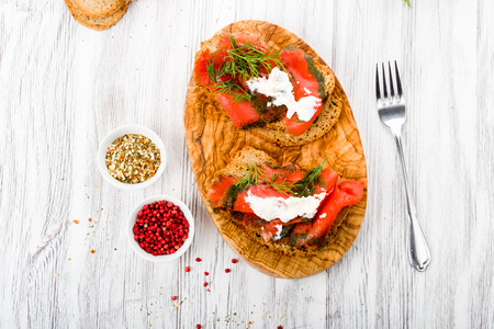 Smoked salmon marinated with fresh dill and spices on wooden boardの写真素材