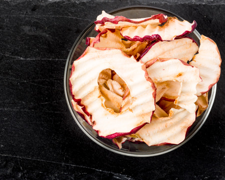 Apple chips with fresh apples on dark undergroundの写真素材
