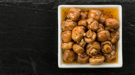 Antipasti mushrooms loaded with fresh herbs in oilの写真素材