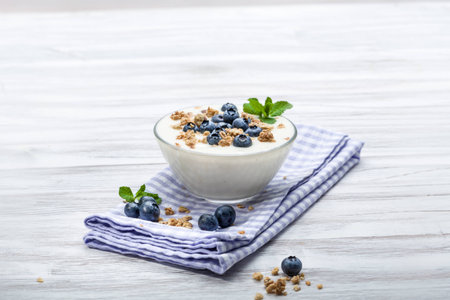 Fresh blueberry yogurt with granola and mint on a backgroundの写真素材