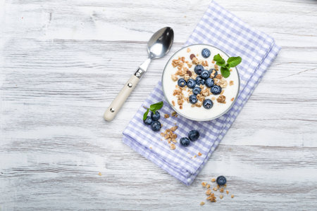 Fresh blueberry yogurt with granola and mint on a backgroundの写真素材