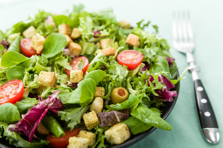Fresh salad with croutons, tomatoes and olivesの写真素材