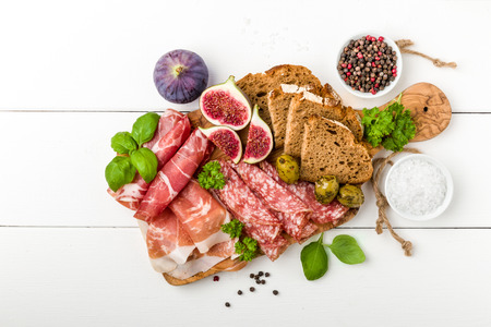 Italian antipasti sausage with figs, olives and fresh herbsの写真素材