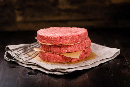 Fresh Burger patties on a wooden backgroundの写真素材