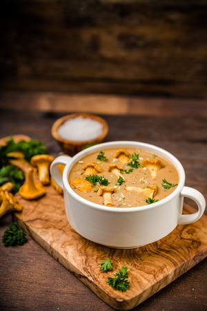 Soup with chanterelles and parsley on woodの写真素材