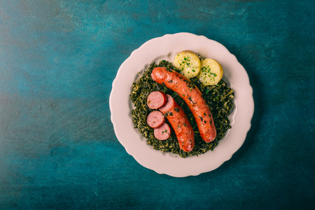 Kale with cooked sausage and potatoes with salt and herbsの写真素材