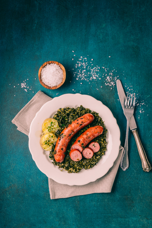Kale with cooked sausage and potatoes with salt and herbsの写真素材