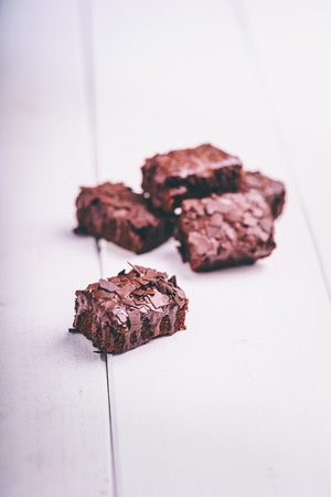Delicious brownie with chocolate covered on white woodの写真素材