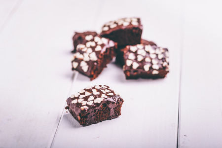 Delicious brownie with chocolate covered on white woodの写真素材