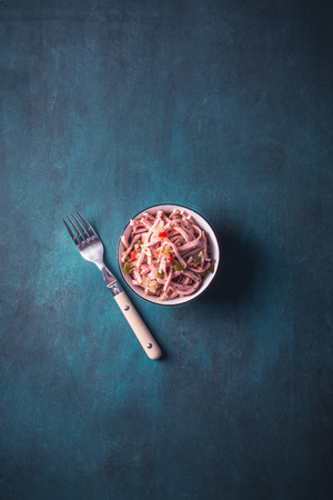 Sausage salad in a bowl on a backgroundの写真素材
