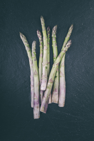 Fresh green asparagus on a slate platterの写真素材