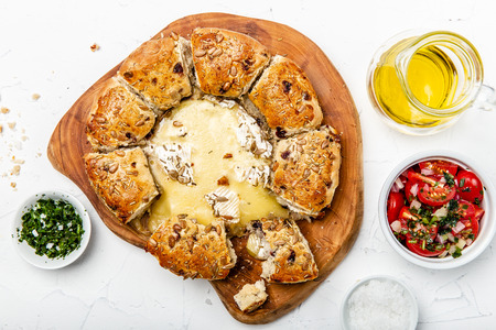 camembert baked in the oven with herb bread served with tomato salad and olive oilの写真素材