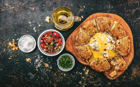 Camembert baked in the oven with herb bread served with tomato salad and olive oilの写真素材