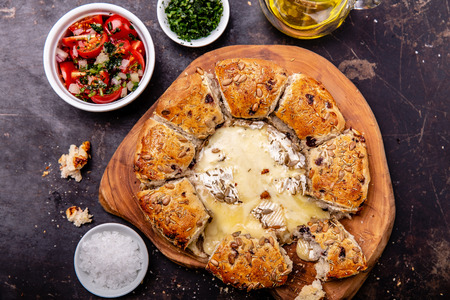 Camembert baked in the oven with herb bread served with tomato salad and olive oil