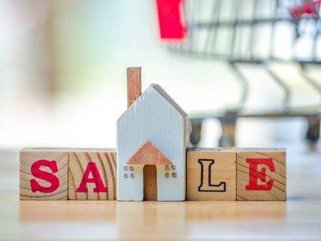 RENT word written cube in front off shopping cart  home on wooden background. Concept for loan, property ladder, financial, mortgage, real estate investment, taxes and bonus.の写真素材