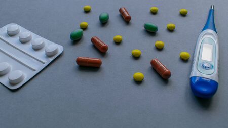 Tablets and caplets on grey background, yellow, green and orange pills, vitamins for preventing getting sick with viruses, immune system boostの写真素材
