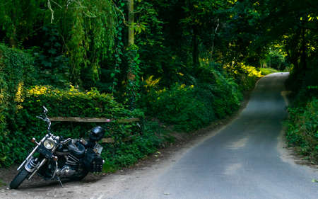 Oldstyle Yamaha motorcycle parked by the long forestry road ready to go.の写真素材