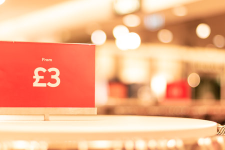 Oxford, UK -14 Dec 2020: Red Sale price tag closeup in Hennes and Mauritz AB store, prices from...