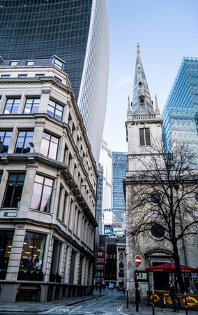 London, UK - 15 Dec 2020: little traditional London city buildings and narrow street with huge skyscrapers towering behind them. Scale of the city's constant grow to show there is a limited space.のeditorial素材