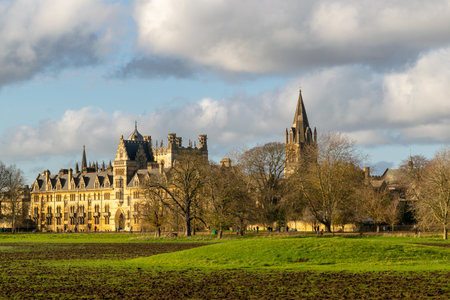 Oxford, UK 22 Nov 2020: Landscape view of Christ Church University from the meadows, popular tourist spot in beautiful sunny and cloudy sky, sandstone Cotswold style architecture, impressive monumental buildingのeditorial素材
