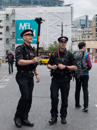 London,UK-28 Aug 2021: Two caucasian police officers standing on the street in London, one policeman...
