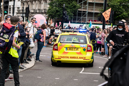 London,UK-28 Aug 2021: Ambulance passing through a large group of protestants at Extinction Rebellion Animal Rights protest, crowd gets out of the way of life saving NHS small BMW car ambulanceのeditorial素材