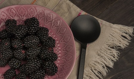 Close-up of fresh blackberries in a bowl on rustic tableの写真素材