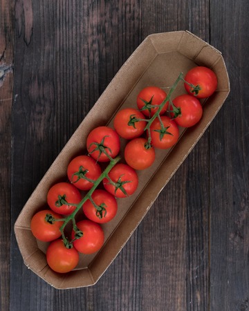 Fresh tomatoes from grapes on a wooden background. in a rustic style. season of vegetables. advertising.の写真素材