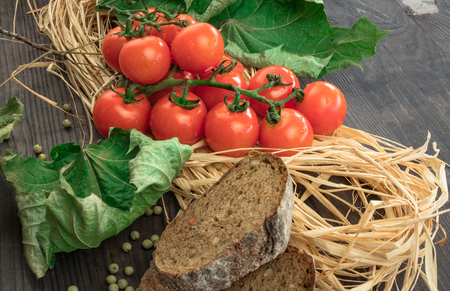 Fresh tomatoes from grapes on a wooden background. in a rustic style. season of vegetables. advertisement.Vegetables from the garden.の写真素材