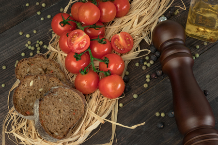 Fresh cherry tomatoes on a wooden table with spices. Top view with a copy.の写真素材