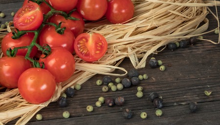 Fresh cherry tomatoes on a wooden table with spices. Top view with a copy.の写真素材