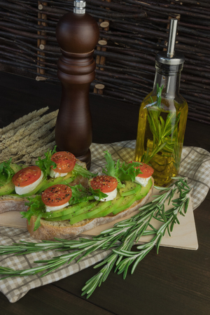 Avocado toast, cherry tomato on wooden background. Breakfast with toast avocado, vegetarian food, healthy diet concept.の写真素材