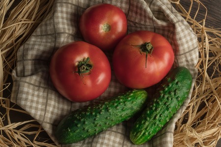 Backyard vegetables, tomatoes and cucumber on wooden background, top viewの写真素材