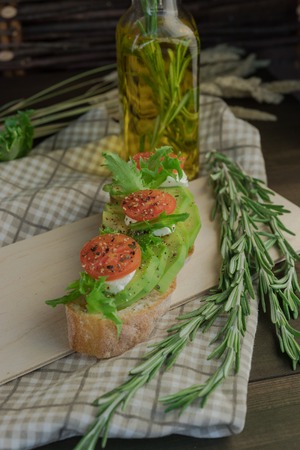 Avocado toast, cherry tomato on wooden background. Breakfast with toast avocado, vegetarian food, healthy diet concept.の写真素材