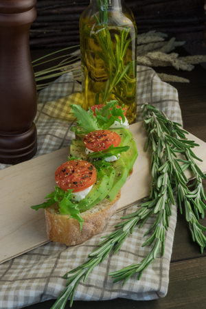 Avocado toast, cherry tomato on wooden background. Breakfast with toast avocado, vegetarian food, healthy diet concept.の写真素材