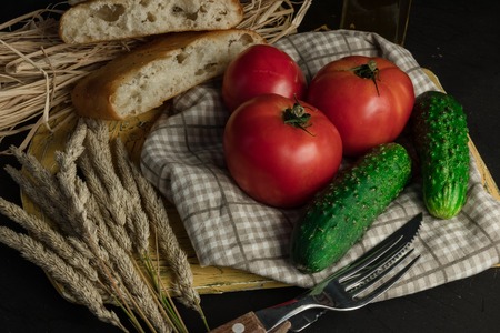 Backyard vegetables, tomatoes and cucumber on wooden background, top viewの写真素材