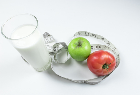A green apple with measurements isolated on a yellow background. fitness food.の写真素材