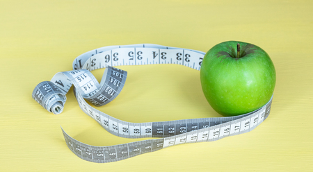 fresh apple with measuring tape. fresh tomato. sour milk product isolated on white backgroundの写真素材