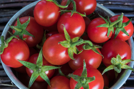 Small red cherry tomatoes in rustic style, selective focus.の写真素材