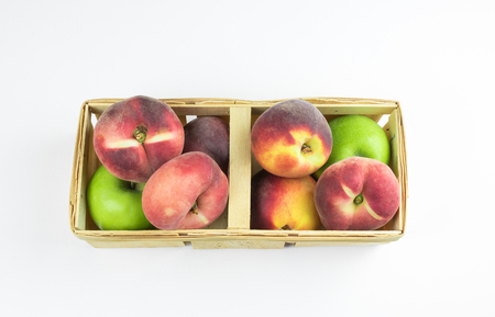 Peaches, apricots and green apples in the basket. isolator of fruit on a white background.の写真素材