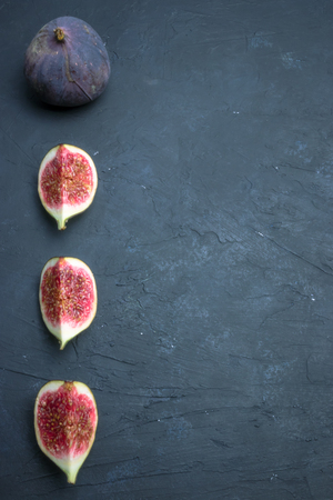 Fresh figs. Food photography. Creative scheme of whole and sliced figs on a dark background, inscribed in a rectangle. Copy spaceの写真素材