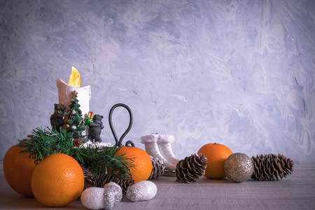 Christmas or New Year composition with a candle, tangerines, and Christmas decorations, pine cones, a place for text. holiday composition of the new year. postcard.の写真素材