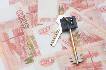 house keys on the background of five thousand rubles banknotes. purchase of real estate. Travel and money.の写真素材
