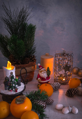 Christmas or New Year composition with a candle, tangerines, and Christmas decorations, pine cones, a place for text. holiday composition of the new year. postcard.の写真素材