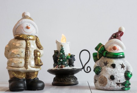 Christmas toy snowman on a light background with decorative candles. Christmas horizontal composition. Christmas decorationの写真素材