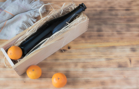 Mandarin, a bottle of champagne. on wooden background mock up.の写真素材