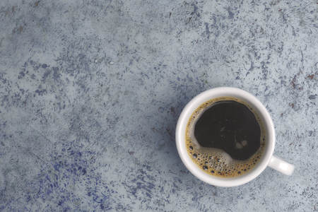 white cup of coffee on the table. view from above. place for text.