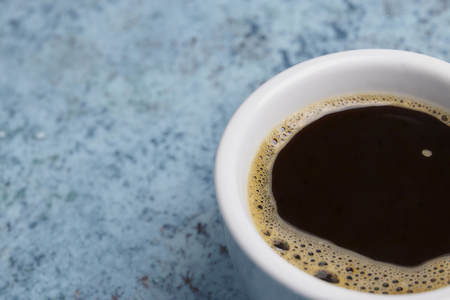 white cup of coffee on the table. view from above. place for text.の写真素材