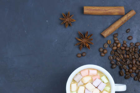 coffee drink with marshmallows and spices. on a dark background. view from above. copy space.